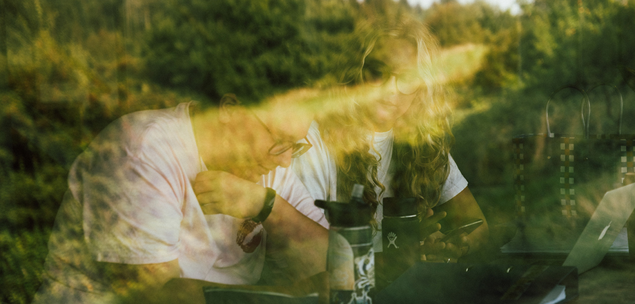 To piger sidder sammen og arbejder på et projekt - vi ser den gennem et vindue. Fra Den Europæiske Filmhøjskole.